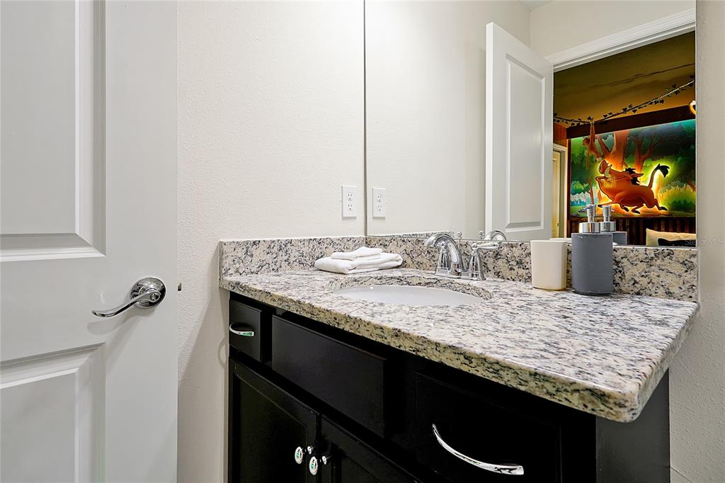 4494 Kaipo Road Davenport, FL 33897 - Photo 73 of 100 a bathroom with a granite countertop sink and a mirror