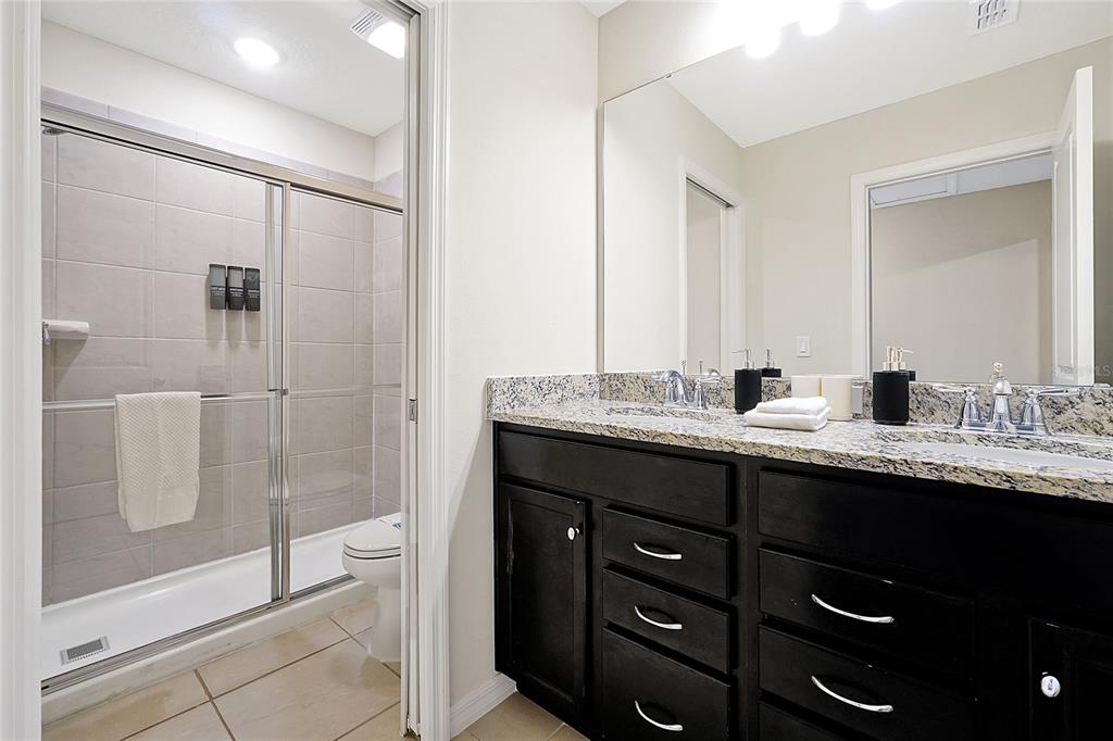 4494 Kaipo Road Davenport, FL 33897 - Photo 78 of 100 a bathroom with a granite countertop sink mirror and double