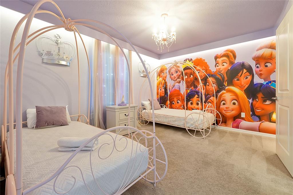 4494 Kaipo Road Davenport, FL 33897 - Photo 90 of 100 a bedroom with a bed and a chandelier