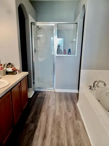 a bathroom with a sink and mirror with bathtub