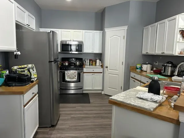 a kitchen with stainless steel appliances granite countertop a refrigerator sink and stove