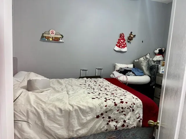 a bedroom with a bed and painting on the wall