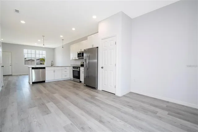a view of kitchen with refrigerator stove microwave and cabinets