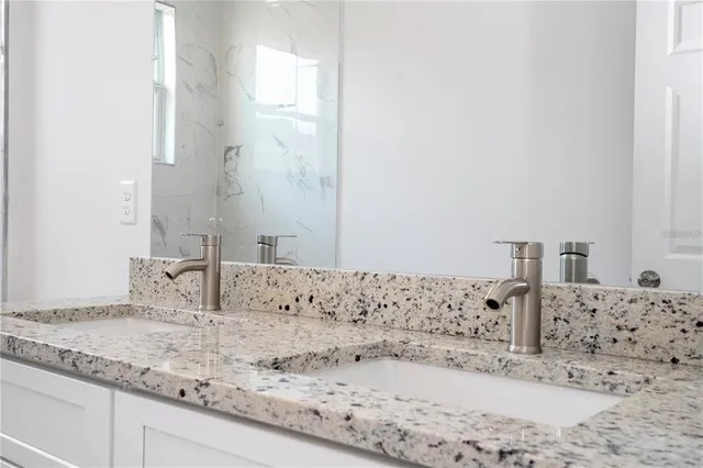 a bathroom with a granite countertop sink and a mirror