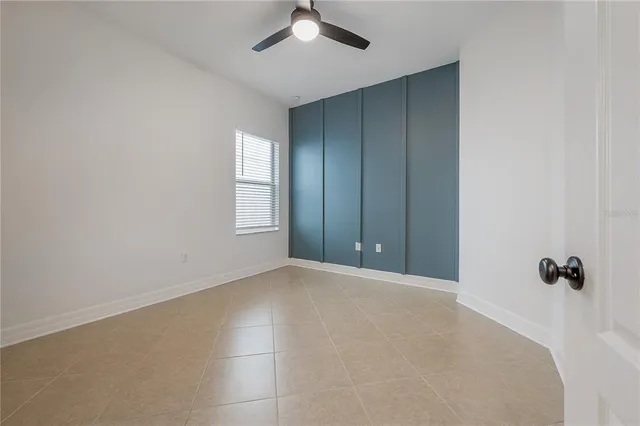 an empty room with a window and a ceiling fan
