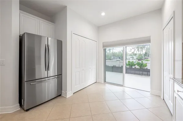 a view of a refrigerator in kitchen and an empty room