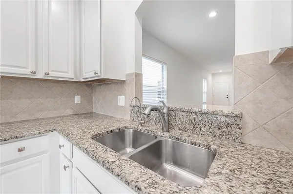 a kitchen with granite countertop a sink and cabinets