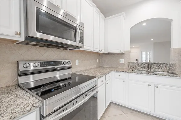 a kitchen with granite countertop a stove microwave and sink