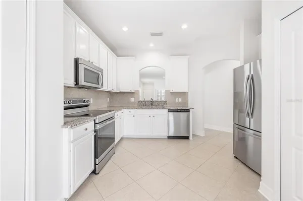 a kitchen with stainless steel appliances granite countertop a refrigerator sink and stove