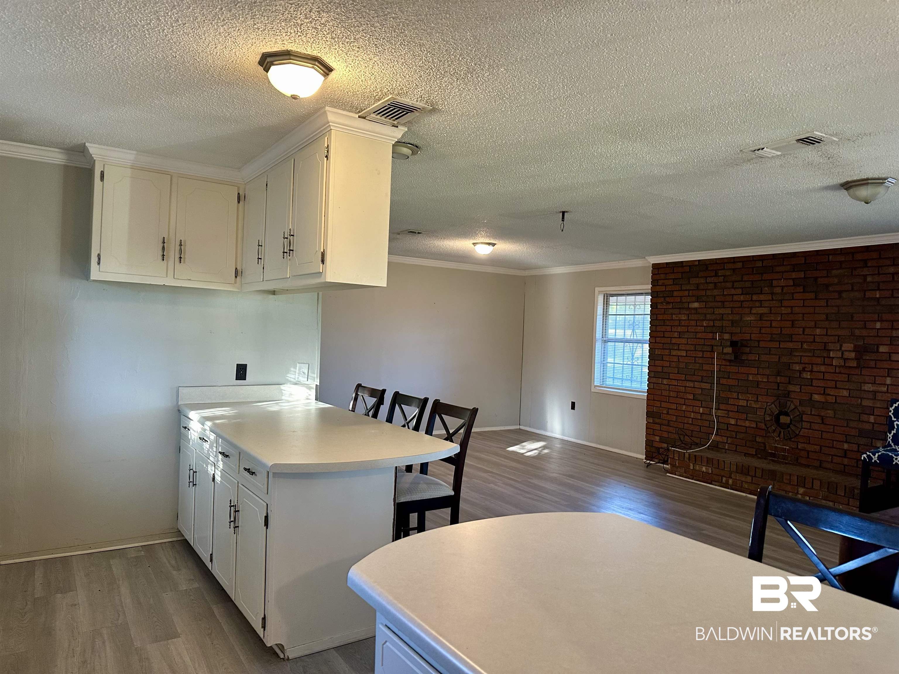 3451 Kirkland Road Brewton, AL 36426 - Photo 5 of 17 Kitchen with wood-type flooring, white cabinetry, and ornamental molding