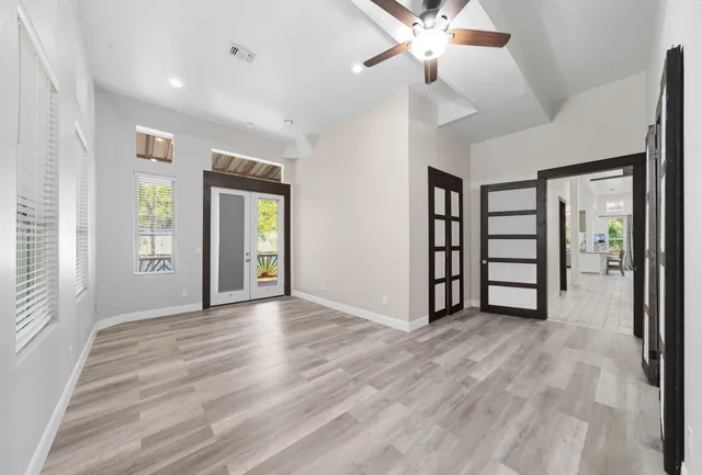 a view of an empty room with window and wooden floor