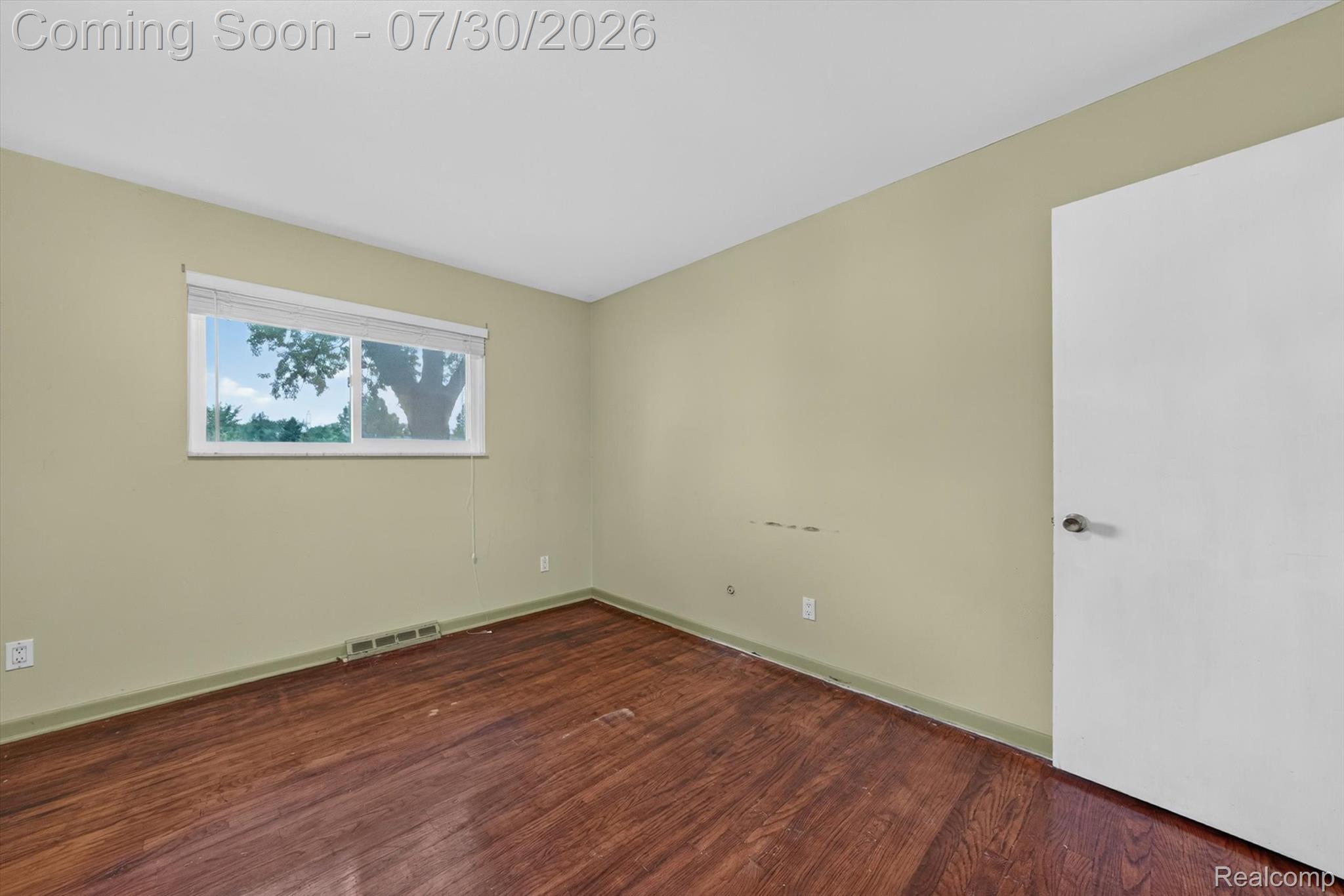 5991 Maybee Road Clarkston, MI 48346 - Photo 12 of 41 Room featuring wood-finish flooring, a white trim baseboard, and a white ceiling