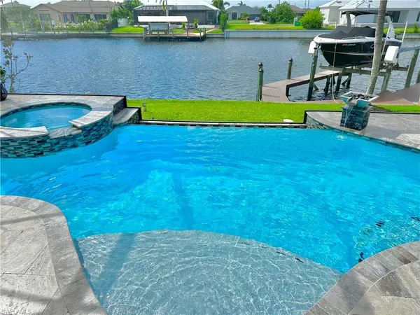 a view of a swimming pool with lounge chair and lake view