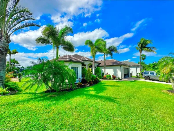 a view of a house with a yard and potted plants