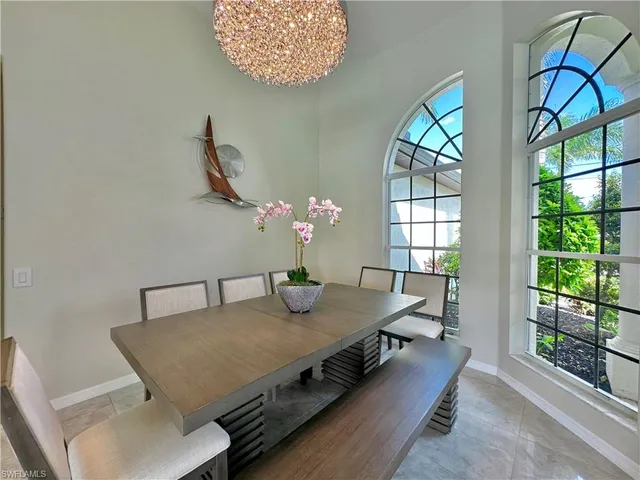 a view of a dining room with furniture a chandelier and wooden floor