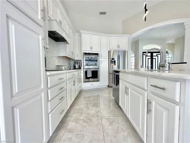 a kitchen with stainless steel appliances granite countertop a refrigerator sink and cabinets