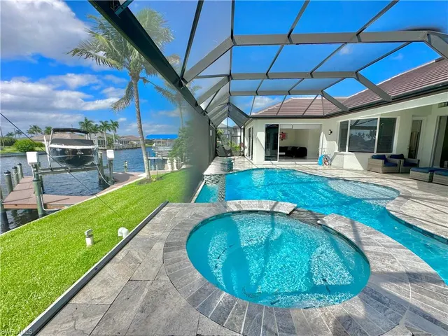 a view of a backyard with table and chairs under an umbrella
