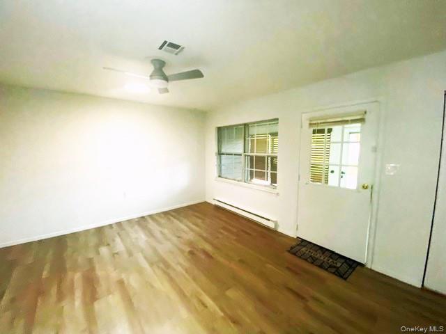 259 Newcastle Court, Unit E Ridge, NY 11961 - Photo 12 of 20 Foyer entrance featuring a baseboard heating unit, dark wood-style flooring, and ceiling fan