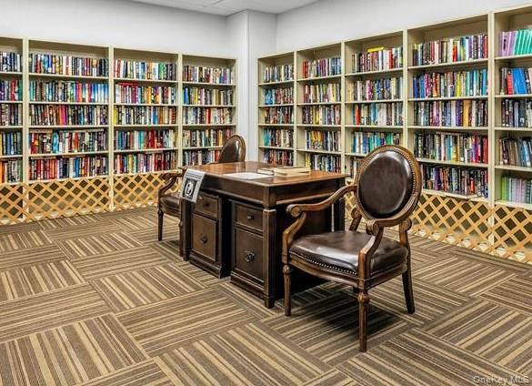 259 Newcastle Court, Unit E Ridge, NY 11961 - Photo 17 of 20 Sitting room featuring bookshelves and carpet floors