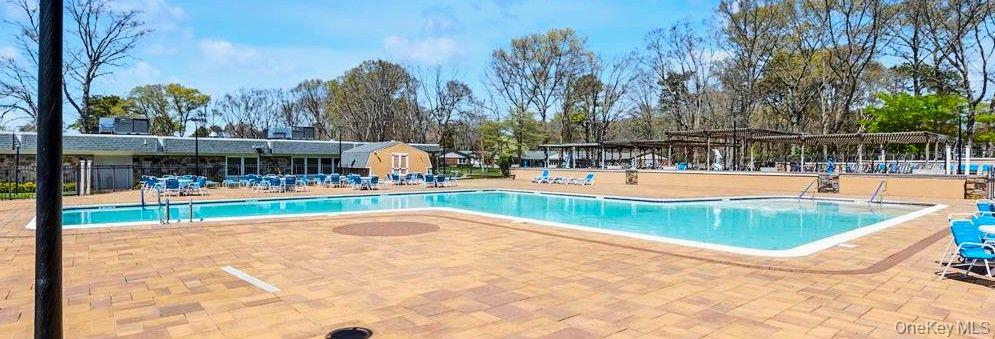 259 Newcastle Court, Unit E Ridge, NY 11961 - Photo 19 of 20 Community pool with a patio