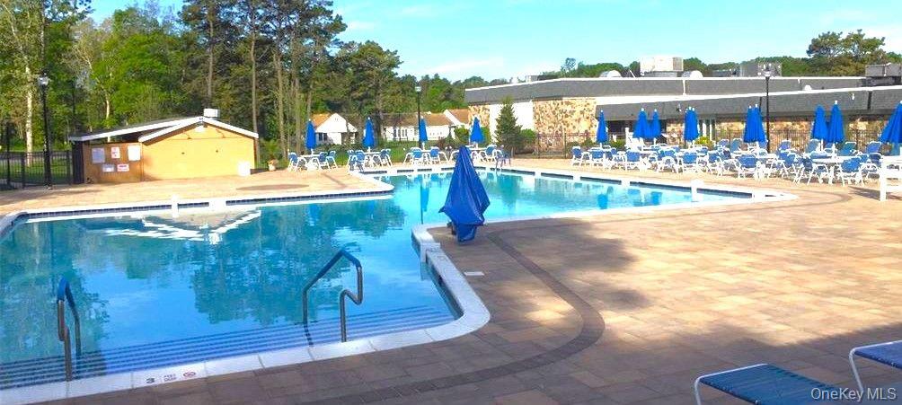 259 Newcastle Court, Unit E Ridge, NY 11961 - Photo 20 of 20 Community pool with a patio