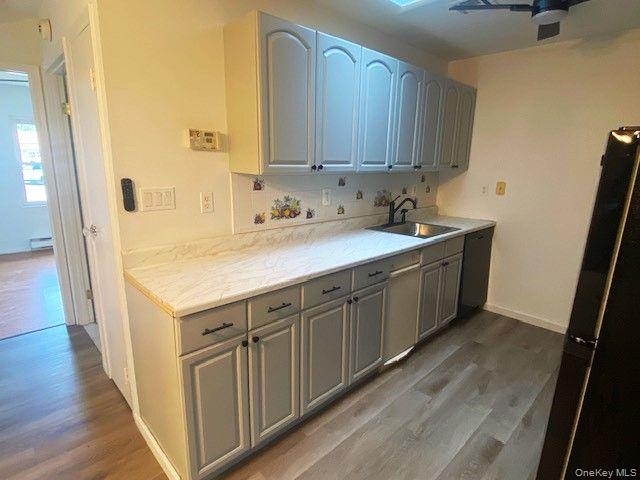 259 Newcastle Court, Unit E Ridge, NY 11961 - Photo 9 of 20 Kitchen featuring wood finished floors, freestanding refrigerator, gray cabinets, and stainless steel dishwasher