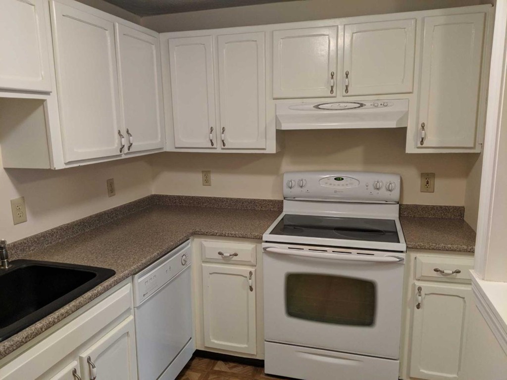 48 Great Road, Unit 22 Acton, MA 01720 - Photo 7 of 18 a kitchen with granite countertop white cabinets and white stove