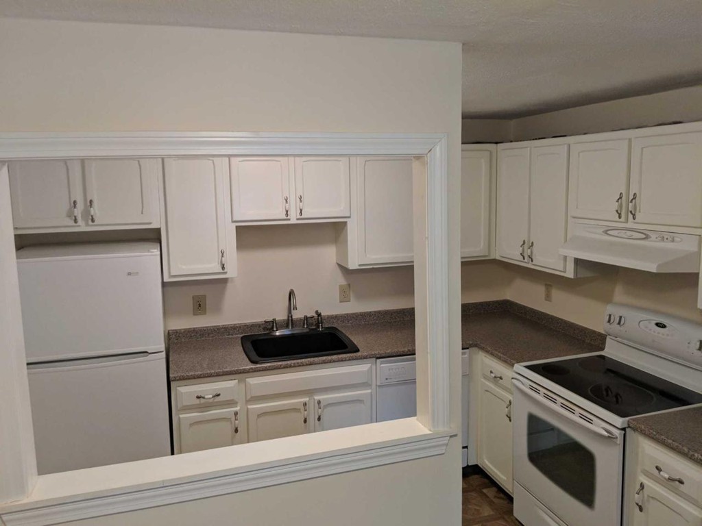 48 Great Road, Unit 22 Acton, MA 01720 - Photo 8 of 18 a kitchen with white cabinets and white appliances