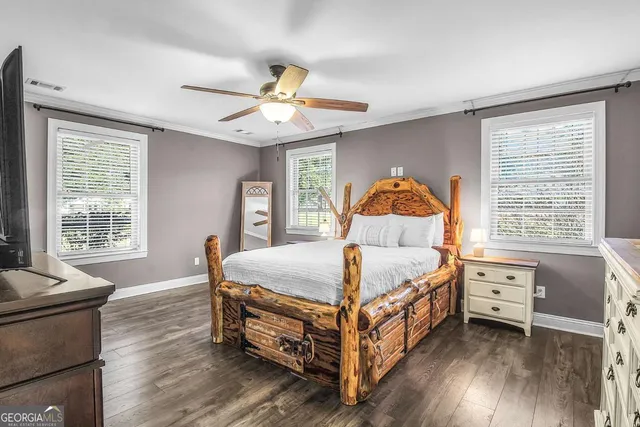 a bedroom with a bed and a flat tv screen on dresser