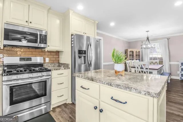 a kitchen with center island table and chairs