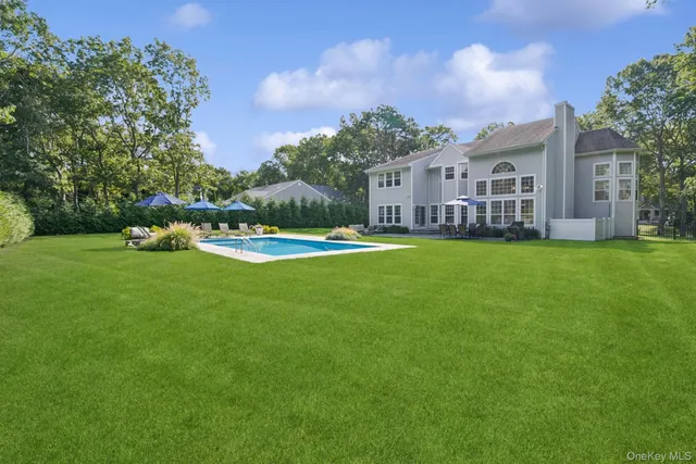 a view of a building with a big yard and large trees
