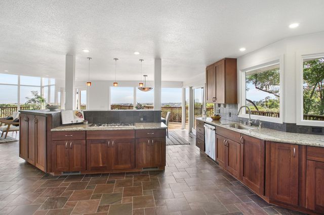 a large kitchen with kitchen island granite countertop a large counter top and stainless steel appliances