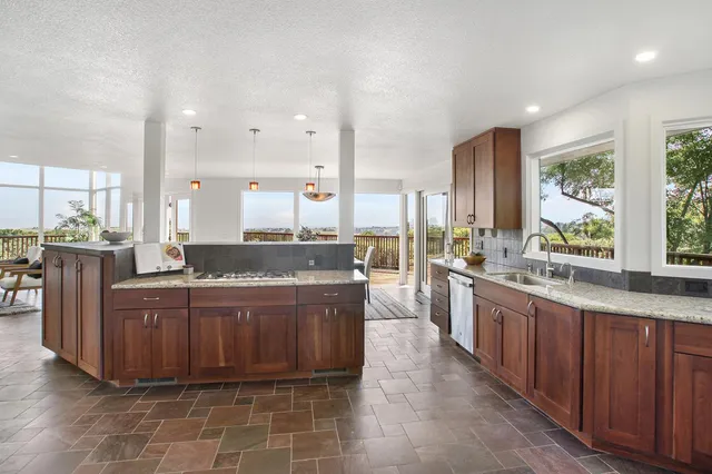 a large kitchen with kitchen island granite countertop a large counter top and stainless steel appliances