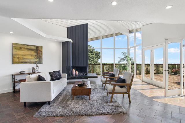 a living room with fireplace furniture and a large window