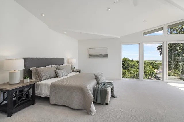 a bedroom with bed and a large window