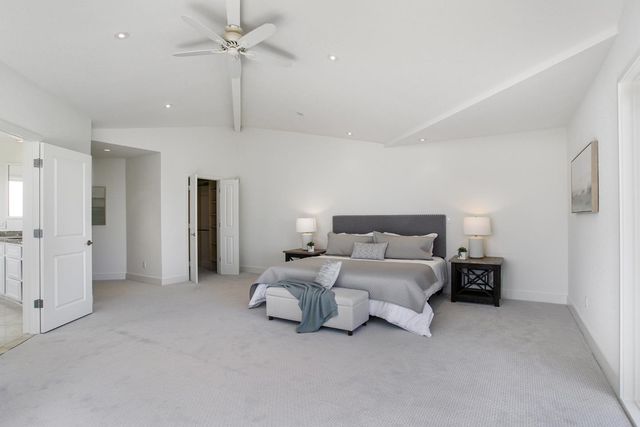 a spacious bedroom with a bed and ceiling fan