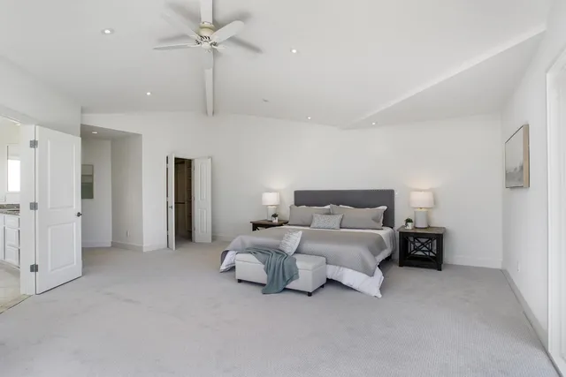a spacious bedroom with a bed and ceiling fan