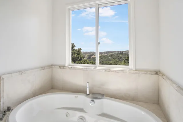 a bathroom with a bathtub and next to a window