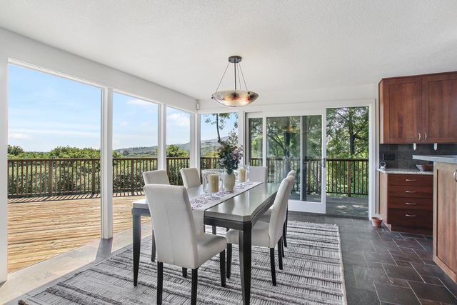 a dining room with furniture large windows and a chandelier