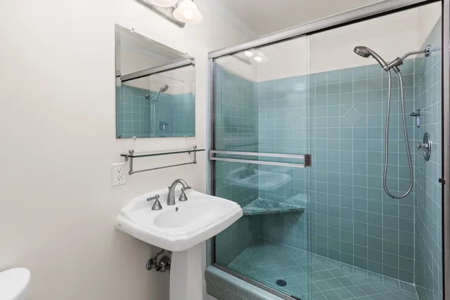 a view of an empty room with wooden floor and a large window