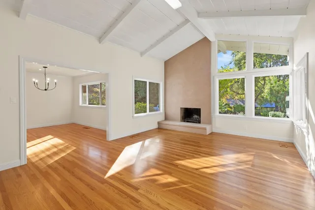 a view of a room with wooden floor ceiling fan and window
