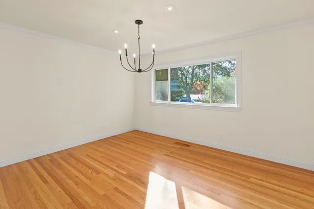 a view of a room with wooden floor and white walls