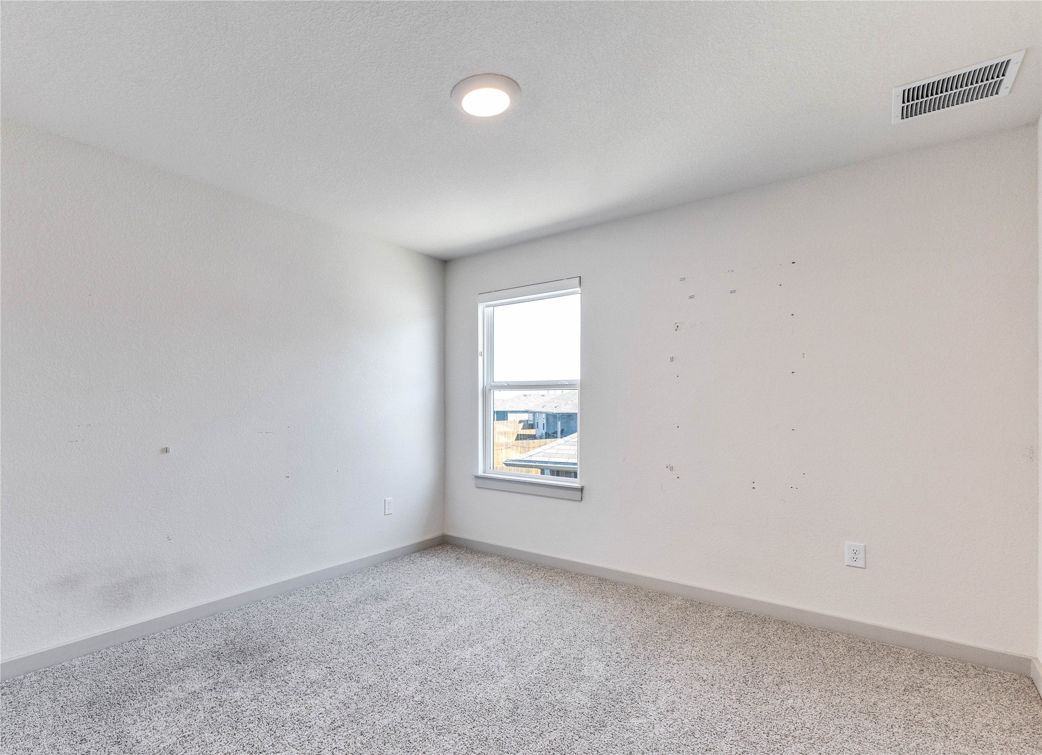 10508 Defender Trail Austin, TX 78754 - Photo 20 of 28 A well-lit bedroom features plush carpeting and a clear window offering neighborhood views.