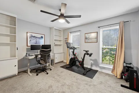 a view of a livingroom with furniture a flat screen tv and windows