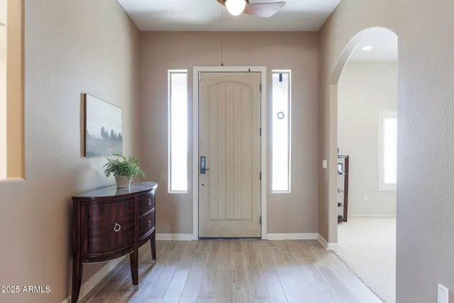 a view of a hallway with wooden floor and a potted plant