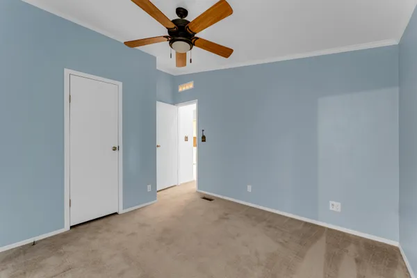 an empty room with closet and a chandelier fan