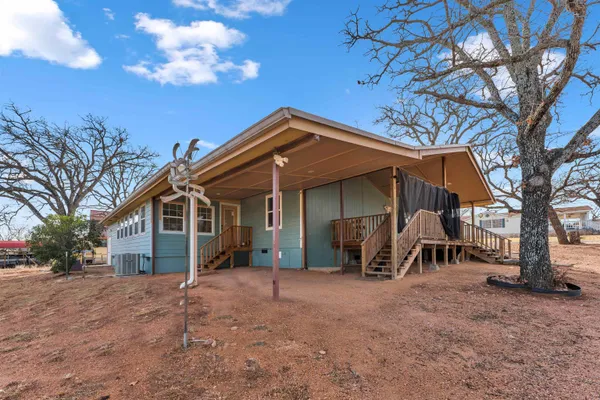 a view of a house with a yard and a large tree