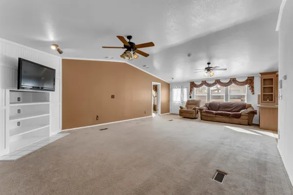 a view of a livingroom with furniture and a ceiling fan