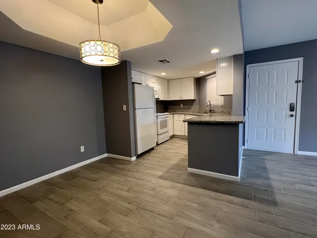 a view of kitchen with granite countertop stainless steel appliances cabinets a sink and a counter top space