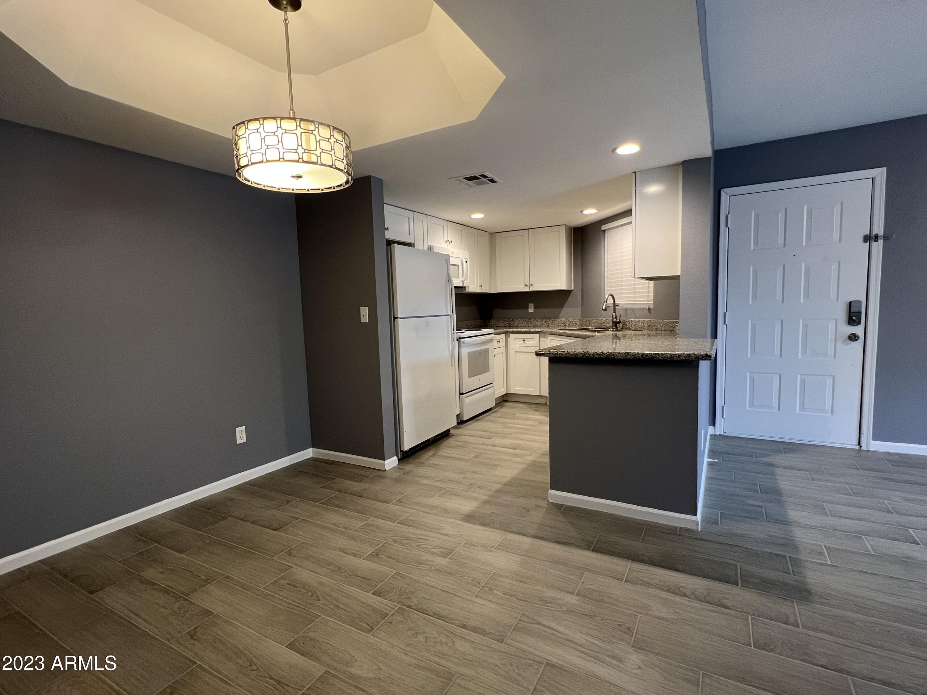 a view of kitchen with granite countertop stainless steel appliances cabinets a sink and a counter top space